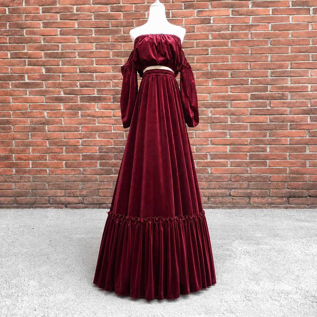 A KO-14,a Belisama velvet off-shoulder top and floor-length skirt are displayed on a mannequin. The two-piece outfit has a ruffled skirt hem.