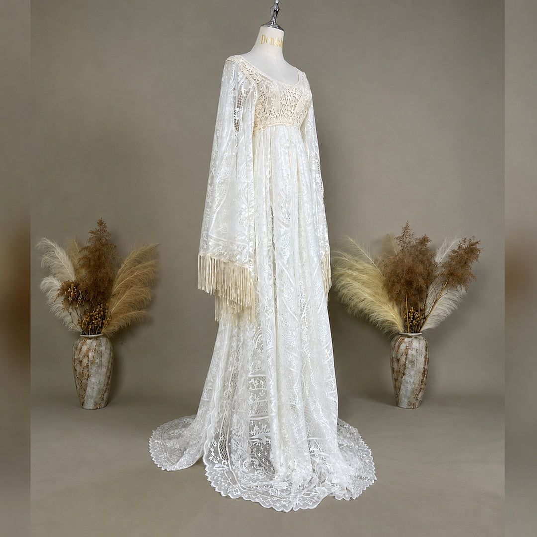 A beige lace gown with fringed cuffs is displayed on a mannequin.
